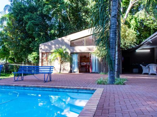 un banco azul sentado junto a una piscina en Riverview Guesthouse, en Upington