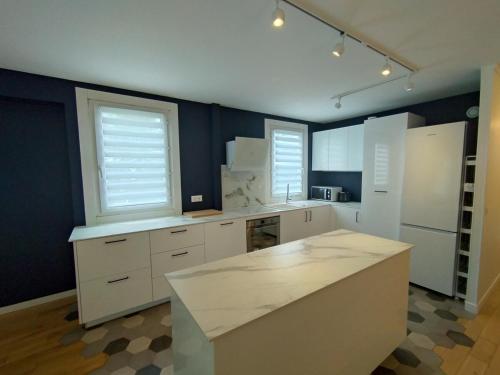 une cuisine avec des armoires blanches et un comptoir dans l'établissement Cozy 3 bedrooms, 5 mn 450m walk Metro La Defense, à Courbevoie