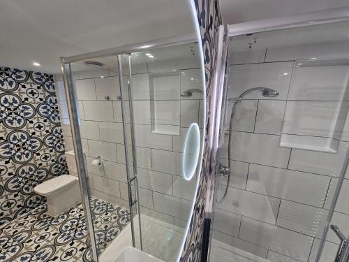 a bathroom with a glass shower with a toilet at St George's Guest House in York