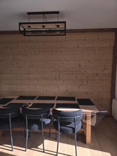 une table et des chaises dans une pièce avec un mur dans l'établissement Catalunya, à Font-Romeu-Odeillo-Via