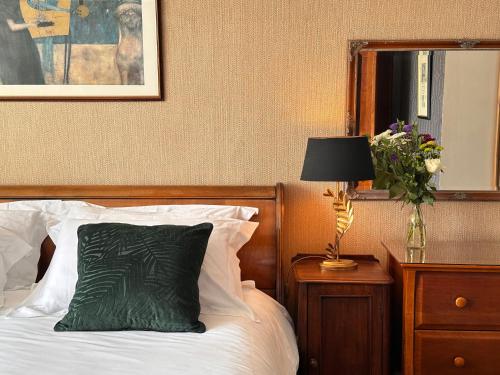 a bed with a green pillow and a lamp on a night stand at St George's Guest House in York