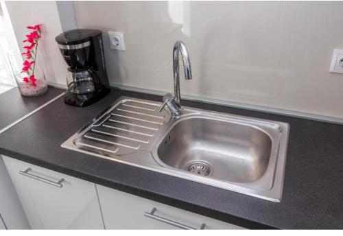 a stainless steel sink in a kitchen with a coffee maker at Apartments & Rooms Jure in Viniština