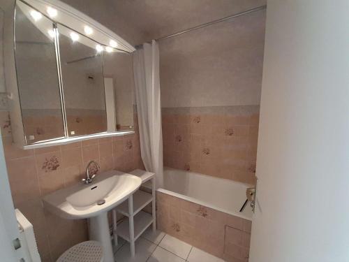 une salle de bain avec un lavabo et une baignoire dans l'établissement Studio Cabine Face à la Mer avec Accès Direct à la Grande Plage - Saint-Gilles-Croix-de-Vie - FR-1-324-62, à Saint-Gilles-Croix-de-Vie