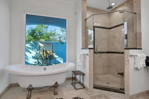 un baño con bañera y ducha de cristal en The Blue Horizon Estate, en Edgewater