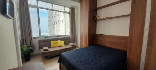 a bedroom with a bed and a window at Apto com Vista para o Mar in Santos