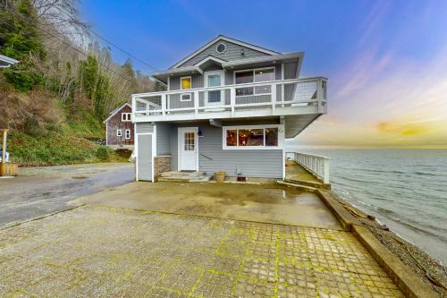 a house on the shore of a body of water at Tyee Shoreline Retreat A in Tyee Beach