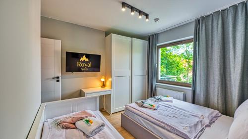 a bedroom with two beds and a window at Apartamenty z basenem i saunami STONE HILL RESORT II VIP Centrum by Royal Aparts in Szklarska Poręba