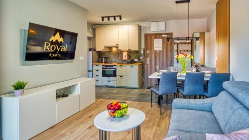 a living room and kitchen with a couch and a table at Apartamenty z basenem i saunami STONE HILL RESORT II VIP Centrum by Royal Aparts in Szklarska Poręba
