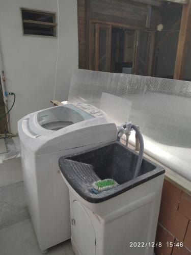 a white toilet in a room with a bucket at Casa com Jacuzzi em Itapoa, 400m da Praia Aceita Pets in Itapoa