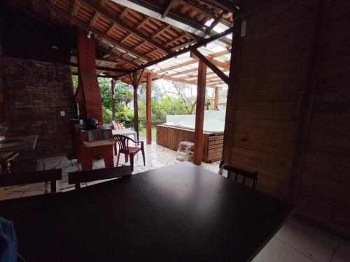 a room with a table and chairs and a tub at Casa com Jacuzzi em Itapoa, 400m da Praia Aceita Pets in Itapoa
