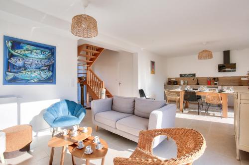 un salon avec un canapé et des chaises dans l'établissement Maison lumineuse pour 8 avec grand jardin, à Saint-Briac-sur-Mer