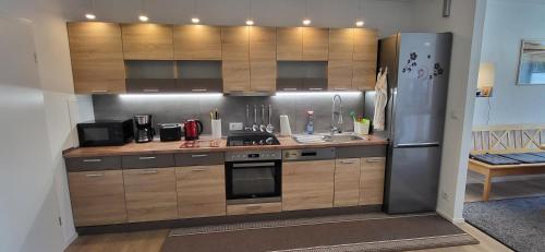 a kitchen with wooden cabinets and a stainless steel refrigerator at Ferienwohnung Schwarzach in Schwarzach