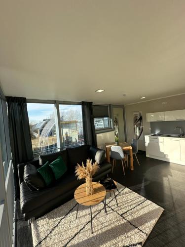a living room with a black couch and a table at Open-Water-Resort in Geierswalde