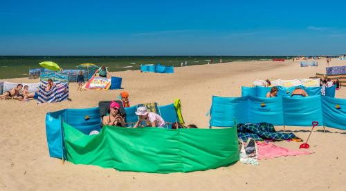 a group of people sitting in chairs on the beach at Interferie Cechsztyn in Ustronie Morskie