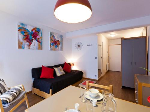 un salon avec un canapé et une table dans l'établissement Studio avec Balcon Sud et WiFi au Centre de Brides-les-Bains, Proche Thermes et Télécabine - FR-1-512-54, à Brides-les-Bains