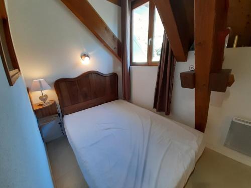 un petit lit dans une chambre avec une fenêtre dans l'établissement Studio cosy proche centre thermal avec mezzanine et wifi - FR-1-512-95, à Brides-les-Bains