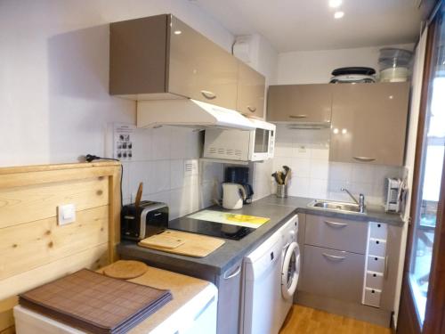 une petite cuisine avec un évier et une cuisinière dans l'établissement Studio 4 pers avec Balcon, Parking et Wi-Fi, Proche Thermes, Brides-les-Bains - FR-1-512-100, à Brides-les-Bains