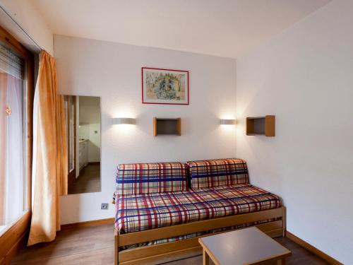 Zimmer mit einem Bett mit einer karierten Decke in der Unterkunft Studio Confortable pour 2 Personnes avec Balcon, Proche Télécabine et Spa à Brides-les-Bains - FR-1-512-114 in Brides-les-Bains
