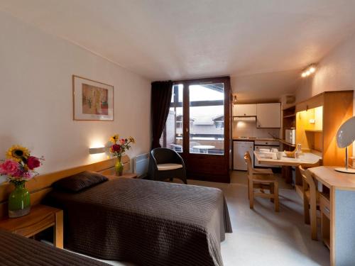 Cette petite chambre comprend un lit et une cuisine. dans l'établissement Studio avec Balcon et Double Exposition à Brides-les-Bains, Près des Thermes - FR-1-512-144, à Brides-les-Bains