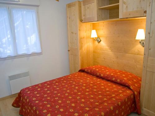 - une chambre avec un lit et un mur en bois dans l'établissement Dernier étage, 3 pièces duplex avec WiFi et animaux acceptés - FR-1-512-221, à Brides-les-Bains