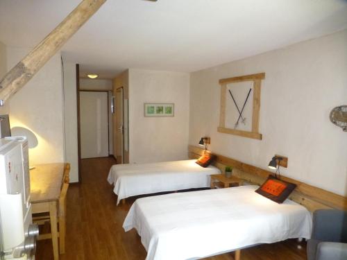 deux lits dans une chambre aux murs blancs et au parquet dans l'établissement Studio lumineux 2* avec balcon, parking et WIFI - 4 pers, proche thermes, calme assuré - FR-1-512-223, à Brides-les-Bains