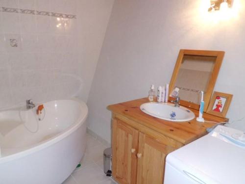 La salle de bains est pourvue d'une baignoire blanche, d'un lavabo et d'une baignoire. dans l'établissement Spacieux Duplex Rénové 2 Pièces, Centre Brides-les-Bains, Proche Parc Thermal, Parking Inclus - FR-1-512-5, à Brides-les-Bains
