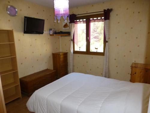 une chambre avec un lit blanc et une fenêtre dans l'établissement Appartement cosy 2 chambres, proche commerces, parking, wifi, animaux admis - FR-1-512-8, à Brides-les-Bains