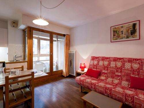 un salon avec un canapé rouge et une table dans l'établissement Studio 2* au Centre de Brides-les-Bains, Balcon, Wifi, Parking Couverts, Proche Télécabine et Spa - FR-1-512-80, à Brides-les-Bains