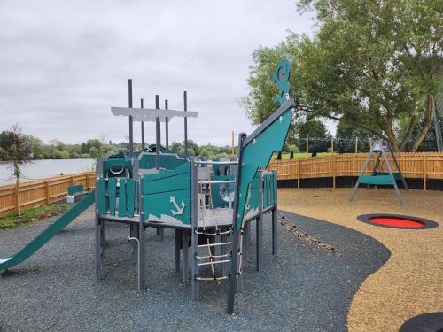 a playground with a slide and a swing at Billing Aquadrome Holiday Park in Great Billing