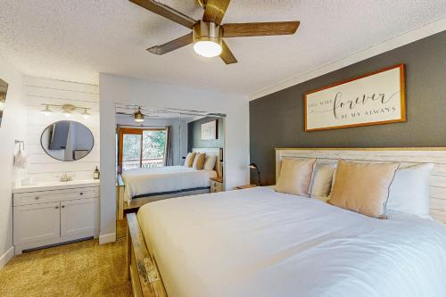 a bedroom with a large white bed and a bathroom at Cozy Mountain Retreat in Flagstaff