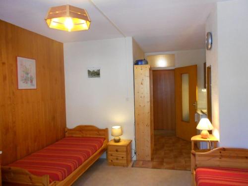 Cette chambre comprend un lit doté d'un couvre-lit rouge. dans l'établissement Studio 2 pers avec balcon est spacieux, centre station proche thermes et télécabine, parking inclus - FR-1-512-151, à Brides-les-Bains