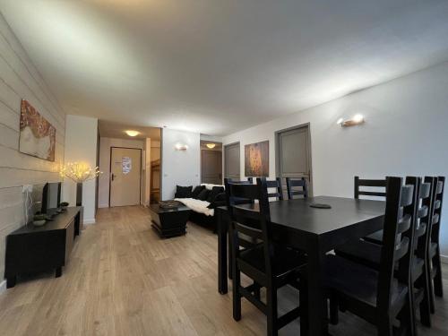 une salle à manger et un salon avec une table et des chaises dans l'établissement Appartement spacieux 8 pers avec balcon, parking et WiFi, proche centre et thermes - FR-1-512-214, à Brides-les-Bains