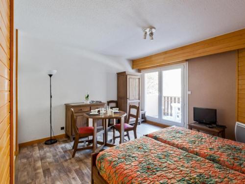 une chambre d'hôtel avec un lit et une table avec des chaises dans l'établissement T1 bis 2* au centre de Brides-les-Bains, 4 pers, balcon, ascenseur, proche thermes et télécabines - FR-1-512-227, à Brides-les-Bains