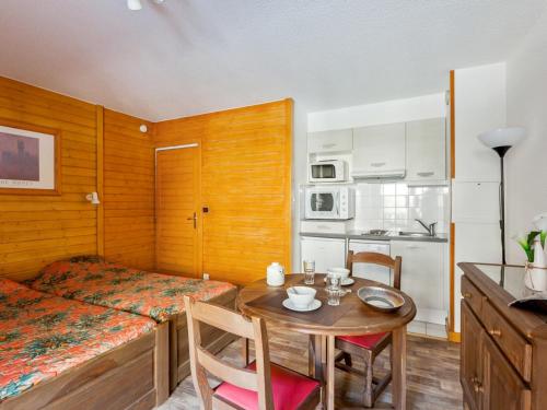 Cette petite chambre comprend une table, un lit et une cuisine. dans l'établissement T1 bis 2* au centre de Brides-les-Bains, 4 pers, balcon, ascenseur, proche thermes et télécabines - FR-1-512-227, à Brides-les-Bains