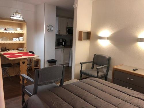 une chambre avec un lit, une table et des chaises dans l'établissement Studio cosy en centre-ville, à proximité des thermes et des pistes du domaine des Trois Vallées - FR-1-512-228, à Brides-les-Bains
