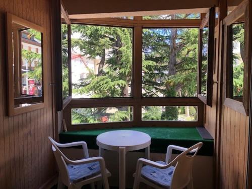 une pièce avec une table, des chaises et une fenêtre dans l'établissement Studio cosy en centre-ville, à proximité des thermes et des pistes du domaine des Trois Vallées - FR-1-512-228, à Brides-les-Bains