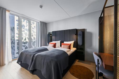 a bedroom with a large bed and a large window at Clarion Hotel Oslo in Oslo