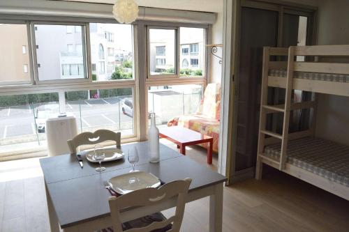 - un salon avec une table, des chaises et des lits superposés dans l'établissement 2 pièces cabine CAP D'AGDE CT610-223, au Cap d'Agde