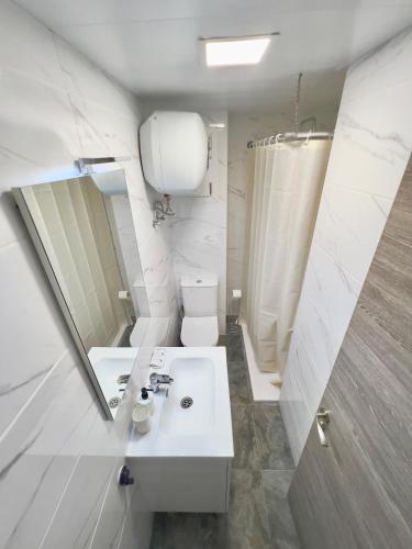 ein weißes Badezimmer mit Waschbecken und Spiegel in der Unterkunft Hotel LM in Lloret de Mar