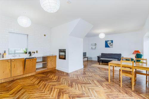 a kitchen and living room with a wooden floor at Beautiful 3 Bed House, Sleeps 5 - No 4 Lyrath in Ashbourne