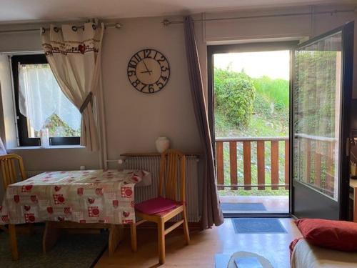 une pièce avec une table et une horloge au mur dans l'établissement Studio Cosy 1* avec Balcon, au Centre de Brides-les-Bains, 2 Pers, Proche Thermes et Télécabine - FR-1-512-253, à Brides-les-Bains