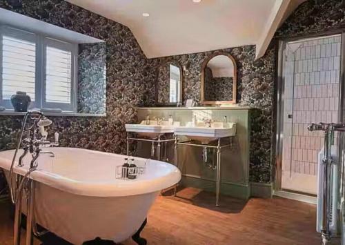a large bathroom with two sinks and a tub at The Manor House Hotel in Moreton in Marsh