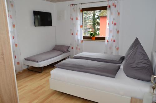 ein Wohnzimmer mit 2 Betten und einem Fenster in der Unterkunft Ferienwohnung Gabler in Landsberg am Lech