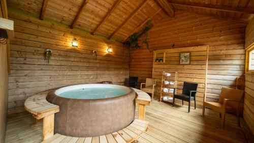 a room with a hot tub in a wooden house at Le Village de la Champagne - Slowmoov in Bar-sur-Aube