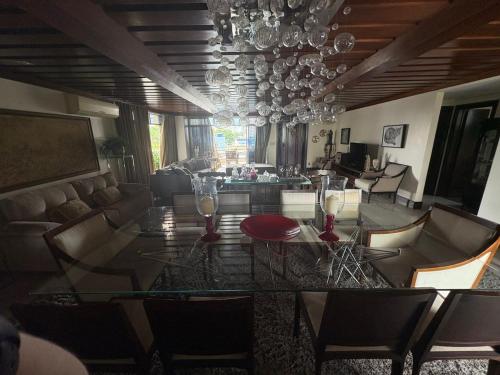 a living room with a glass table and chairs at COP 30 - Apartamento Amplo in Belém