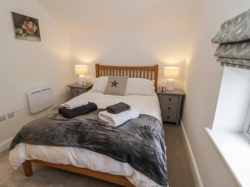 Un dormitorio con una cama con dos almohadas encima. en Plum Barn, en Daventry