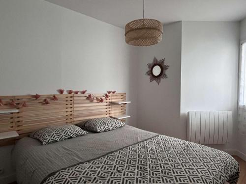 une chambre avec un grand lit et un miroir dans l'établissement Appartement rénové avec terrasse au Pouliguen, proche plage, port et commerces - FR-1-392-235, au Pouliguen