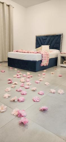 un mucchio di petali di rosa rosa sul pavimento accanto a un letto di استراحة آدم a Barka