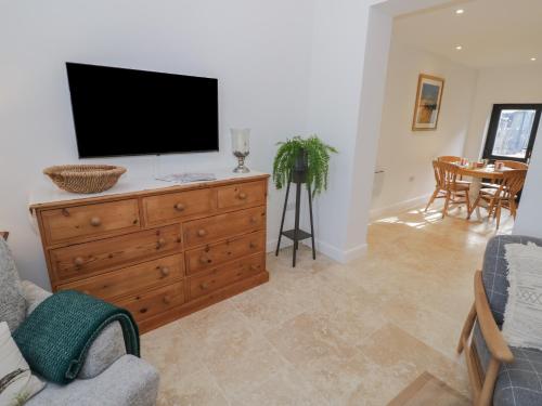 a living room with a television on a wooden dresser at Pear Barn in Daventry