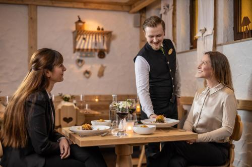 three people sitting around a table in a restaurant at Hotel & Restaurant Zum Reussenstein in Böblingen